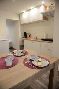 une cuisine avec une table en bois et deux assiettes de nourriture dans l'établissement Wohnen am Kaiserturm, à Quedlinbourg