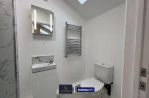 une salle de bain avec toilettes, lavabo et miroir dans l'établissement Luxury 3 Bed, 2 Bathroom By Tranquil Ventures Short Lets & Serviced Accommodation Littlemore With Free Private Parking, à Oxford 19 autres photos