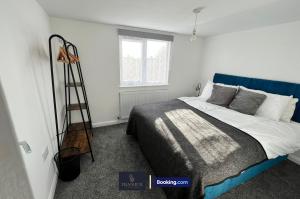 - une chambre avec un lit à tête bleue dans l'établissement Luxury 3 Bed, 2 Bathroom By Tranquil Ventures Short Lets & Serviced Accommodation Littlemore With Free Private Parking, à Oxford