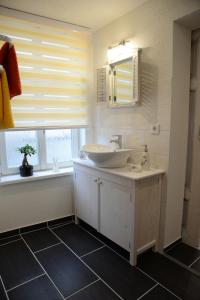 a bathroom with a sink and a mirror and a window at Wohnen am Kaiserturm in Quedlinburg +8 photos