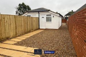 un garage blanc avec une clôture devant dans l'établissement Luxury 3 Bed, 2 Bathroom By Tranquil Ventures Short Lets & Serviced Accommodation Littlemore With Free Private Parking, à Oxford