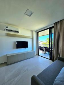 a living room with a flat screen tv on the wall at Sofisticação e Luxo à Beira-mar no Cais Eco em Muro Alto by HM in Porto De Galinhas