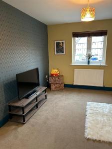 a living room with a flat screen tv and a window at Wonderful two bedroom house in Bicester in Chesterton