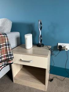 a nightstand with a lamp on it next to a bed at Wonderful two bedroom house in Bicester in Chesterton +30 photos