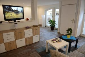 a living room with a flat screen tv on the wall at Wohnen am Kaiserturm in Quedlinburg