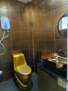 a bathroom with a yellow toilet and a sink at Newstar Jacuzzi Homestay Near Jonker Kota Laksamana Melaka in Melaka