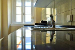 a kitchen with a counter with a sink and a window at Stay DP Setúbal in Setúbal