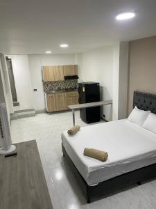 a bedroom with a large bed and a kitchen at Hotel Boutique Casa Teresita in Medellín