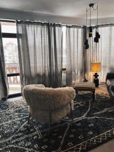 Una sala de estar con una silla y una ventana grande. en Black Mura, en Bansko 2 fotos más