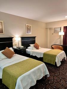 a hotel room with two beds and two chairs at Condado Hotel Casino Goya in Goya