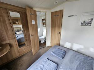 a small bedroom with a bed and a toilet at Heidi 2 Bed Robin hood in Rhyl +3 photos