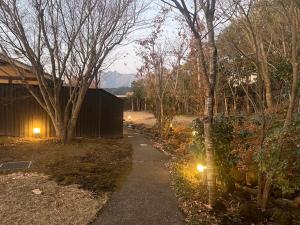 a path in a yard with trees and a building at 御宿だいこんや in Takamori +6 photos
