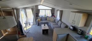 a living room with a couch and a table at Mikey caravan with Balcony in Rhyl