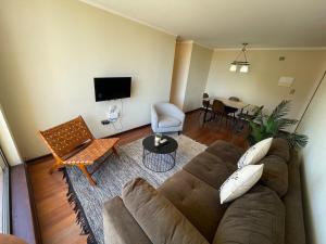a living room with a couch and a table at Bello y acogedor departamento 2D in Los Ángeles