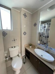 a bathroom with a toilet and a sink at Bello y acogedor departamento 2D in Los Ángeles +3 photos
