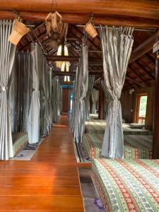 a row of beds in a room with curtains at Homestay Maison de Kathy & Claude in Buon Ma Thuot
