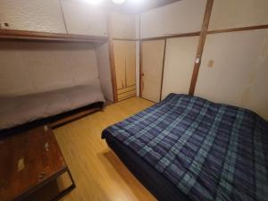 una piccola camera da letto con un letto in una stanza di Sara a Kagoshima