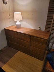 a wooden dresser with a lamp on top of it at Sara in Kagoshima