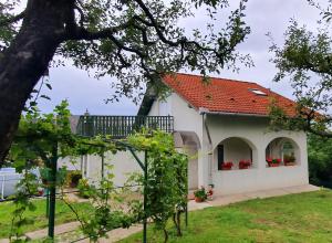 uma casa branca com um telhado vermelho em Sziklaszirt - Wellnes Vendégház em Salgótarján