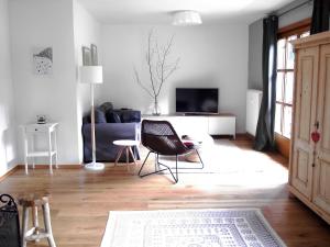 ein Wohnzimmer mit einem Sofa und einem Stuhl in der Unterkunft Ferienwohnung Oberammergau in Oberammergau