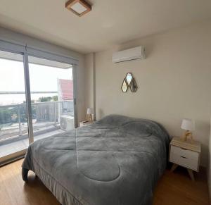 a bedroom with a bed and a large window at Hermoso Zona Norte Río in Rosario
