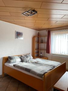 a bedroom with a large bed with a wooden ceiling at Ferienwohnung im Herzen Schönach in Herdwangen-Schönach