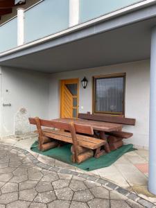 a large wooden bench sitting on the side of a building at Ferienwohnung im Herzen Schönach in Herdwangen-Schönach