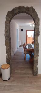 a room with a stone archway with a table and chairs at Apartman Domcek in Ždiar