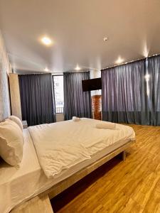 a bedroom with a large white bed with curtains at Solo Palace in Rustavi +10 photos