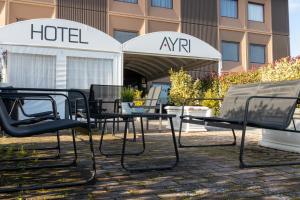 a group of chairs and tables in front of a hotel at Hotel Ayri in Medesano