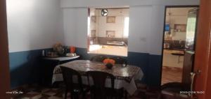 ein Esszimmer mit Tisch und eine Küche in der Unterkunft Varshinicottage kothkiri in Kotagiri