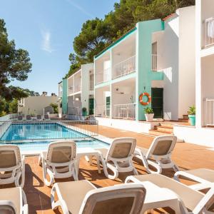 Un complejo con piscina y tumbonas. en Apartamentos Alta Galdana Playa by Escape Home, en Cala Galdana