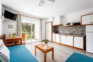 una sala de estar con un sofá y una mesa en Apartamentos Alta Galdana Playa by Escape Home, en Cala Galdana