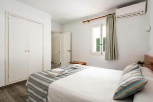 Un dormitorio con una cama con dos toallas encima. en Apartamentos Alta Galdana Playa by Escape Home, en Cala Galdana 12 fotos más