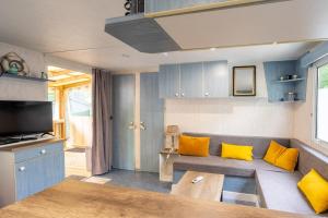 sala de estar con sofá y almohadas amarillas en Mobilhome Mh75 La Tremblade, en La Tremblade