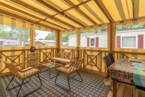 un porche cubierto con sillas y mesa en Mobilhome Mh75 La Tremblade, en La Tremblade