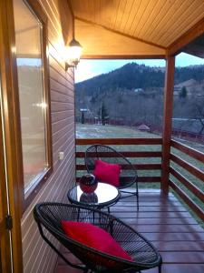 een patio met 2 stoelen en een tafel op een veranda bij Котедж Тиша in Rivnya +25 foto's