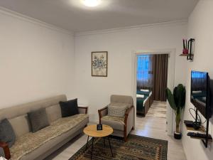 a living room with a couch and a table at Uniluxury Hotel Prishtina in Prishtinë