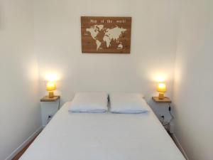 a bed in a room with two lamps on both sides at Le Bellevue - Focalimmo in Foix