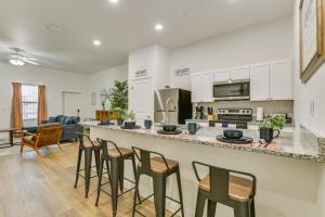 a kitchen and living room with a bar with stools at Walkable Downtown LaBelle Apt with Private Balcony! in La Belle