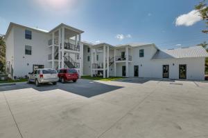 a large white building with cars parked in a parking lot at Walkable Downtown LaBelle Apt with Private Balcony! in La Belle