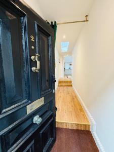 a room with a black door and a hallway at Spacious, Worcester city centre 2 bedroom apartment in Worcester