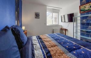 una camera da letto con un letto con lenzuola blu e una finestra di Amazing Home In Neuilly Le Vendin a Neuilly-le-Vendin