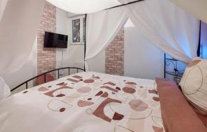 una camera da letto con un letto con un copriletto bianco e una finestra di Amazing Home In Neuilly Le Vendin a Neuilly-le-Vendin Altre 23 foto