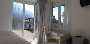 a bedroom with a desk and a window with a view at Appartamenti Villa Eden in Malcesine