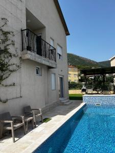 a house with a swimming pool next to a building at Private luxurious house with pool for 15 people in Tivat