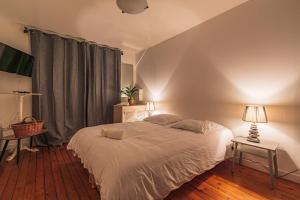 a bedroom with a bed and a table with a lamp at Bar à Bulles - Ancien Comptoir Transformé in Reims