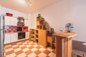 a kitchen with white cabinets and a checkered floor at Bar à Bulles - Ancien Comptoir Transformé in Reims