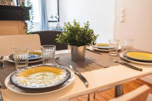 a table with plates and glasses on top of it at Bar à Bulles - Ancien Comptoir Transformé in Reims