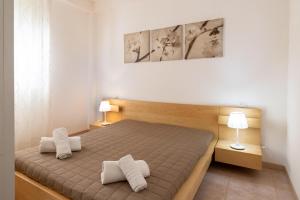 a bedroom with a bed with two white towels on it at Casa Cycas in Santa Maria Del Focallo